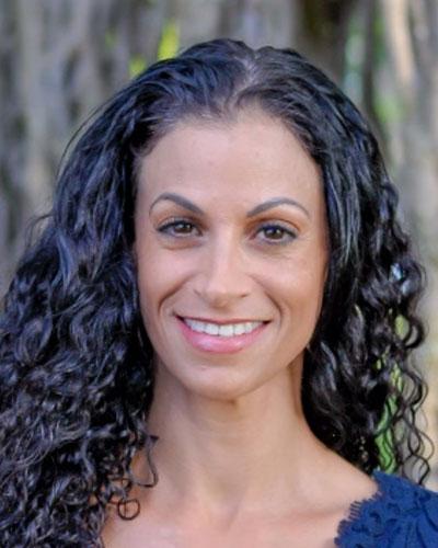 Sara, a smiling woman with long dark curly hair