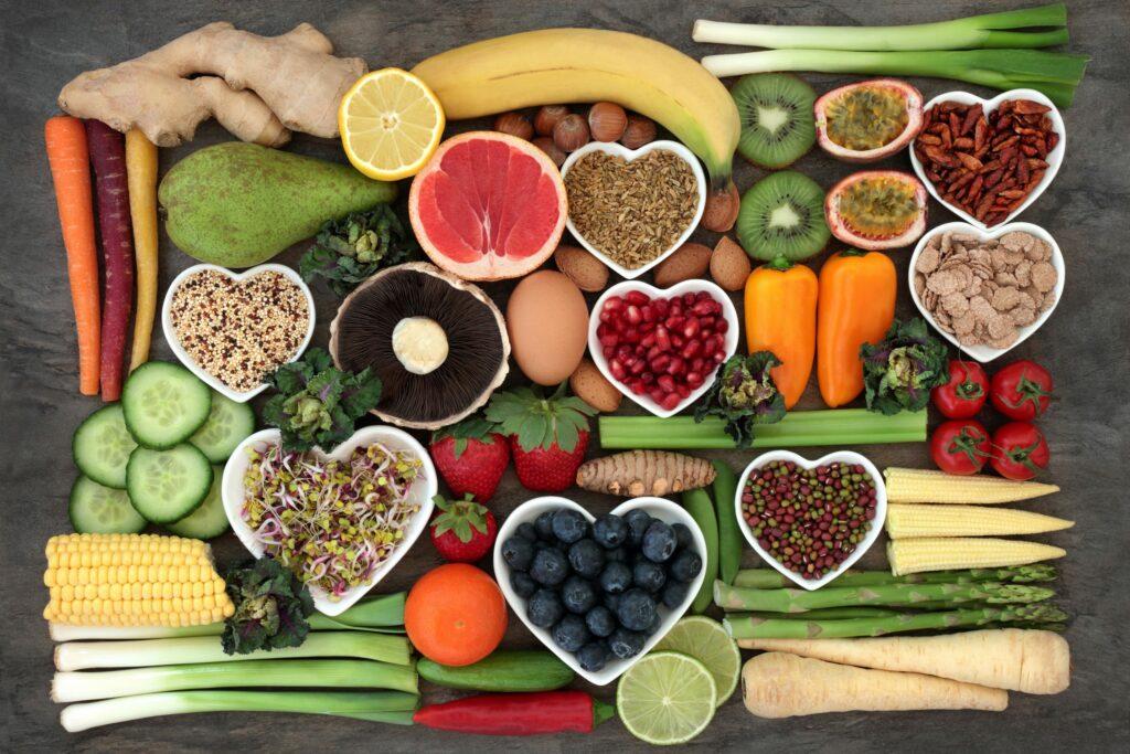Fruits, vegetables, grains and seeds arranged in bowls, several of them heart-shaped