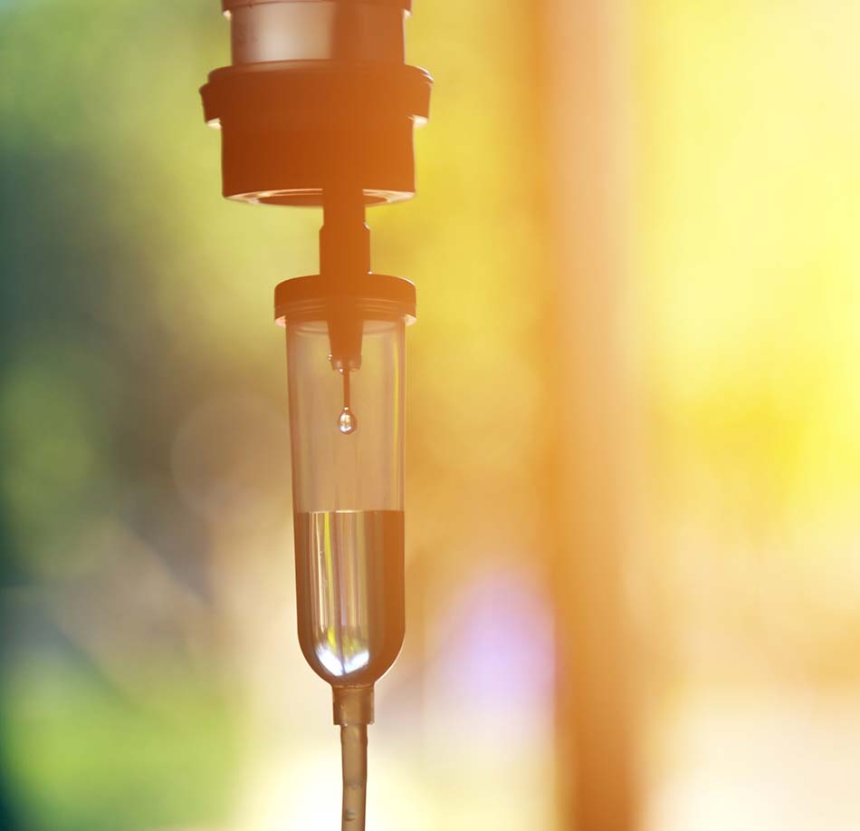 Close-up of an IV drip chamber with a falling drop
